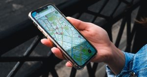 A hand holding a smartphone showing a city street map app
